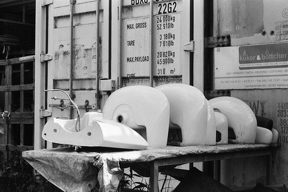 Some old faucets on a table next to cargo containers. Shot Fomapan 400 action.